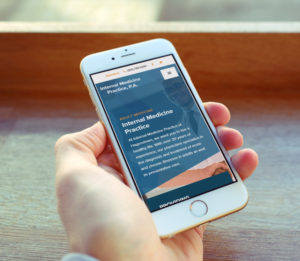 Man holding iphone with Internal Med Website on screen